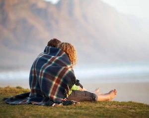 Couple sit under blanket planning their future