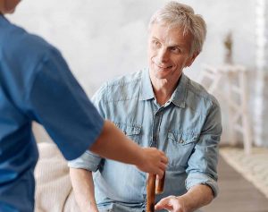 Older man being helped to his feet following injury