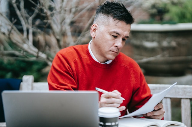 Man in red checking paperwork